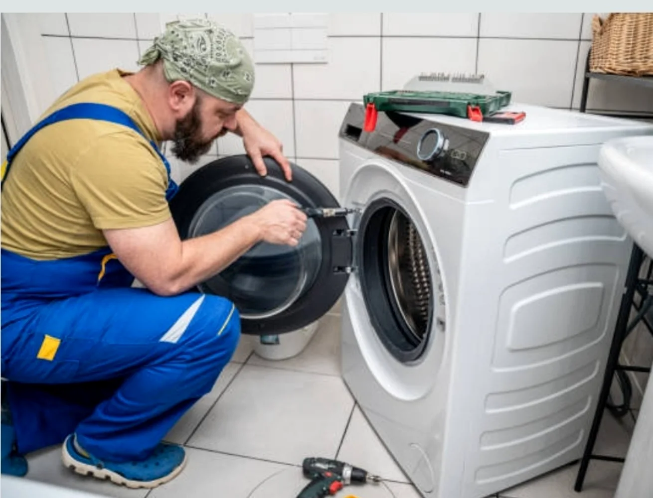 Technician repairing a washing machine for appliance repair in The Meadows Dubai