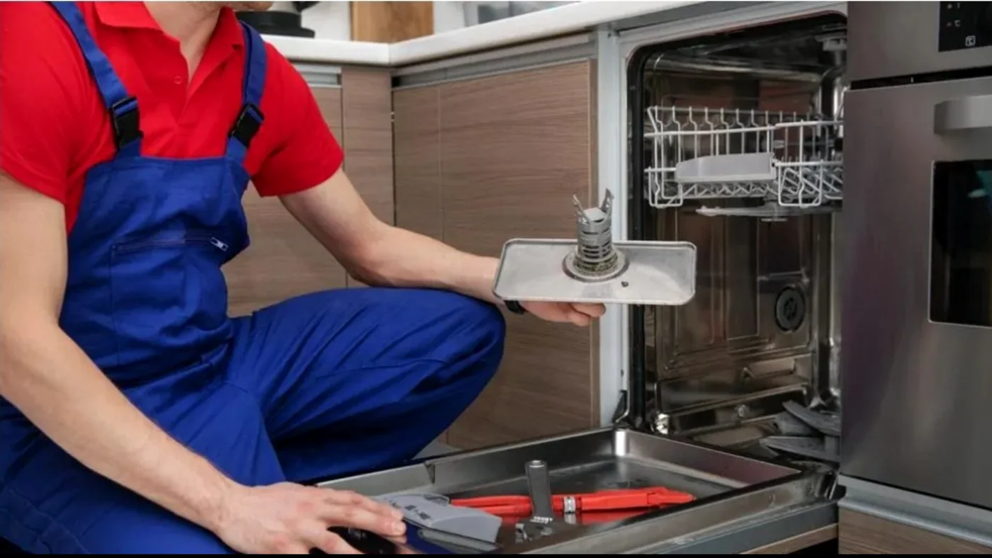 Technician repairing dishwasher in a modern kitchen