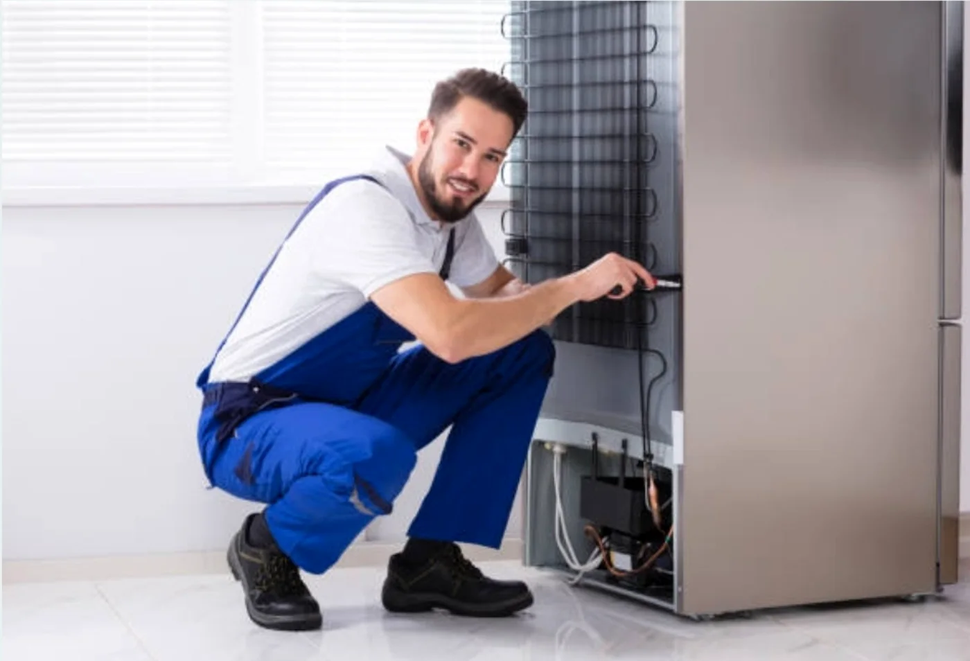 Technician checking the rear cooling system of a refrigerator